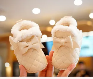 Detail of warm quilted baby winter boots with soft faux fur lining and cute leather bow