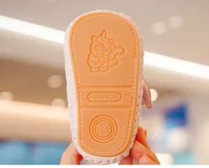Macro view of anti-slip rubber baby shoe sole with embossed unicorn and size 14 detail