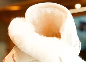 Close-up of baby winter snow boots with thick white faux fur lining and bear pattern