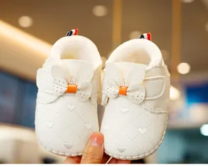 Detail of white infant walking shoes with rabbit ears and heart-shaped quilted design
