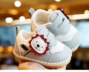 Detailopname van baby-leerschoentjes met leeuw-ontwerp en zachte antislipzool voor baby's