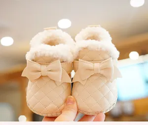 Detail of baby winter walking shoe with quilted leather, bow and faux fleece lining
