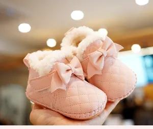 Close-up of pink baby pre-walker shoes with quilted pattern and warm faux fur lining