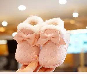Close-up of pink quilted baby boots with soft faux fur lining and a cute bow detail