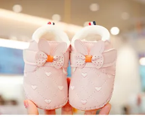 Detail of pink baby walking shoes with heart embroidery and warm fleece lining