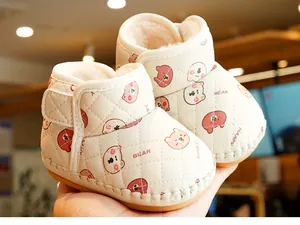 Detail of warm winter baby shoes with plush lining and cute cartoon bear pattern