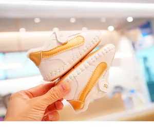 Detail mit Plüsch-Kunstfellfutter und Klettverschluss an weißen Baby-Lernlaufschuhen