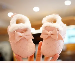Close-up of pink baby shoes with quilted faux leather, bow detail and warm fleece lining