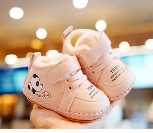 Detail view of pink baby winter boots with thick white faux fur lining and panda motif