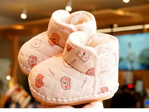 Detail of pink baby snow boots with quilted bear patterns and warm fleece lining