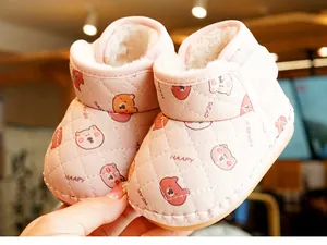 Detail of pink fleece-lined baby winter boots with quilted texture and cute bear pattern