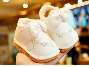Close-up of baby girl winter boots with floral embroidery, bow detail and faux fur lining