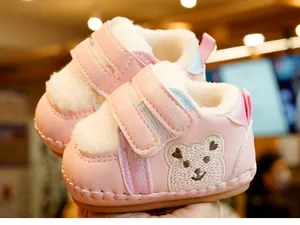 Detail of warm pink baby walker boots featuring soft faux fur lining and bear embroidery