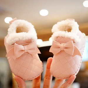 Pink fleece-lined baby winter walking shoes with quilted design and bow detail