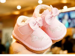 Detailed close-up of pink toddler winter boots with floral embroidery and fur lining
