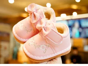 Detail of pink toddler shoes with floral embroidery, bow accents and warm fleece lining