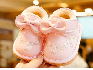 Detail of pink baby winter boots with warm plush lining and flower embroidery