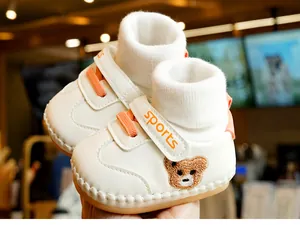 Detail showing baby walker shoe with soft sole, orange velcro, and cute bear embroidery