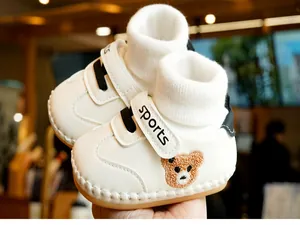 Detail of baby walking shoes with bear embroidery, soft sole and warm lining