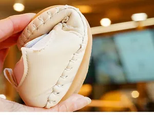 Macro shot showing the flexible soft sole and handmade stitching of beige baby walking shoes