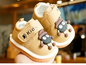 Detail of toddler soft-sole shoe with velcro strap and cute cartoon doll ornament