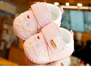 Detailed view of pink baby walker shoe with lace, flower embroidery and Honey buckle