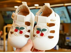Detail of baby summer sandals featuring cherry embroidery and heart lace decor