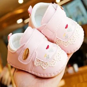 Pink infant walking shoes with lace trim and flower embroidery on soft non-slip sole