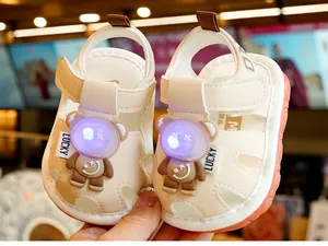 Detail of toddler sandal with bear doll design and glowing eyes on soft anti-slip sole