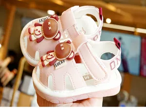 Close-up of pink toddler sandals with protective toe cap and 3D bear decoration