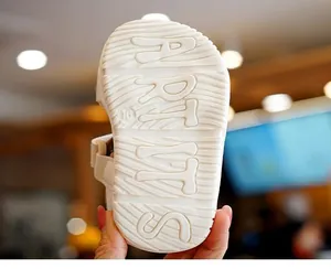 Close-up of baby sandal sole with wavy anti-slip texture and embossed logo