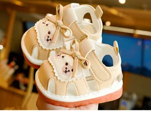 Close-up of baby sandal showing cute bear embroidery, soft leather and velcro strap