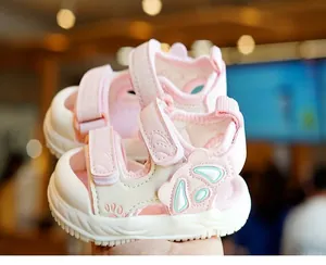 Detail of pink baby sandals with butterfly wings and protective closed toe design