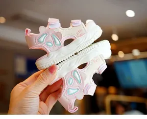 Detail view of pink and white toddler sandals with velcro strap and cartoon decoration