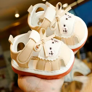 Cream white baby sandals with orange sole, bear embroidery and velcro strap closure