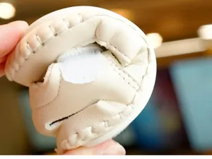 Close-up of flexible off-white baby leather shoes with soft sole for toddlers