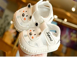 Detail of white baby sandal featuring a cartoon bear design and breathable cutouts