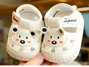 Detailed close-up of white baby sandals featuring a cute bear face and Sport velcro strap