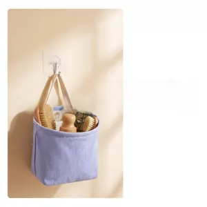 Lavender canvas hanging storage bag mounted on wall with a transparent adhesive hook