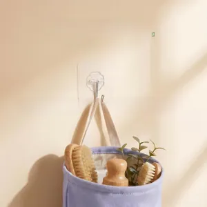 Strong transparent self-adhesive wall hook holding a storage basket in a modern kitchen