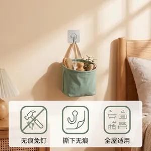 Strong adhesive wall hook holding a green fabric storage basket in a bedroom setting