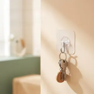 Transparent adhesive wall hook showing metal hook holding a set of keys on a wall