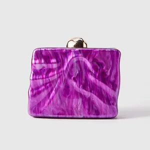 Detail of purple marble acrylic evening bag with gold clasp and wavy texture