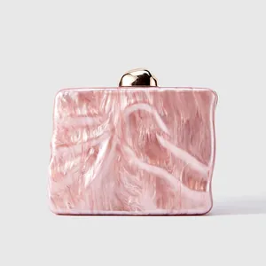 Macro shot of pink marble texture acrylic evening clutch with gold metal buckle detail