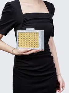 Detail of green woven acrylic clutch showing textured resin frame and elegant handle