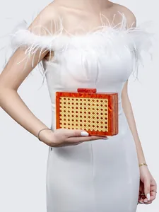 Detailed shot of amber acrylic evening clutch featuring natural woven rattan inlay detail