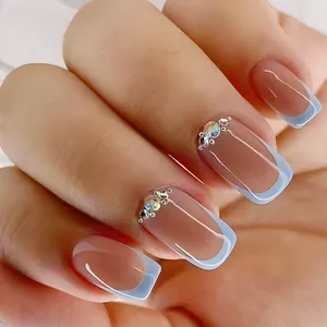 Macro detail of French style square press-on nails with blue tips and rhinestone accents