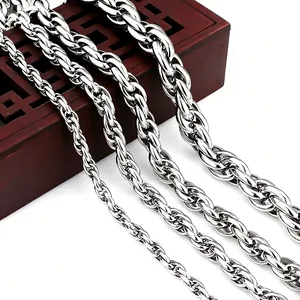 Detail view of four polished stainless steel twist chains in varying thickness on red wood box