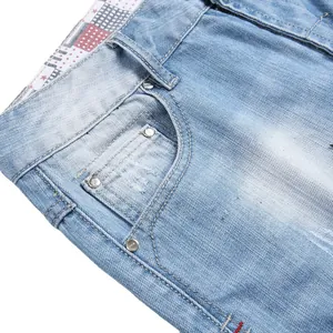 Close-up of light blue washed denim shorts with metal rivets and plaid waist lining