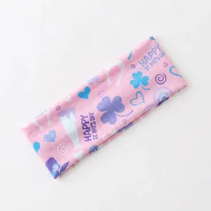 Detail of pink St. Patrick's Day elastic headband with shamrock and horseshoe prints